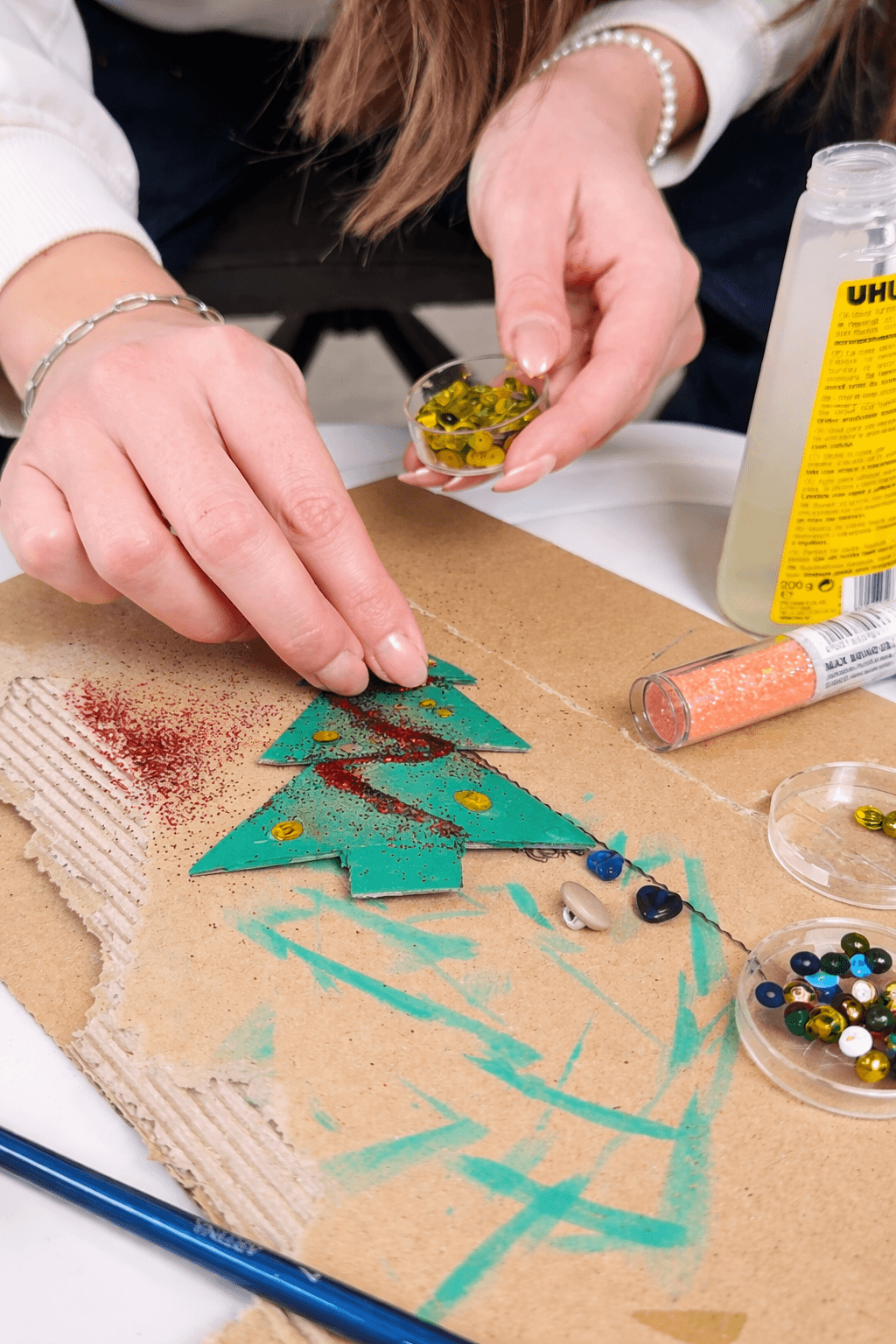 Erzieherin bastelt einen Weihnachtsbaum aus Pappe.