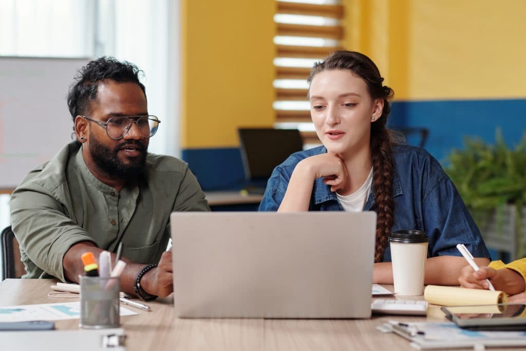 Zwei Fachkräfte im Gespräch am Laptop – Zusammenarbeit im Kinderschutz.