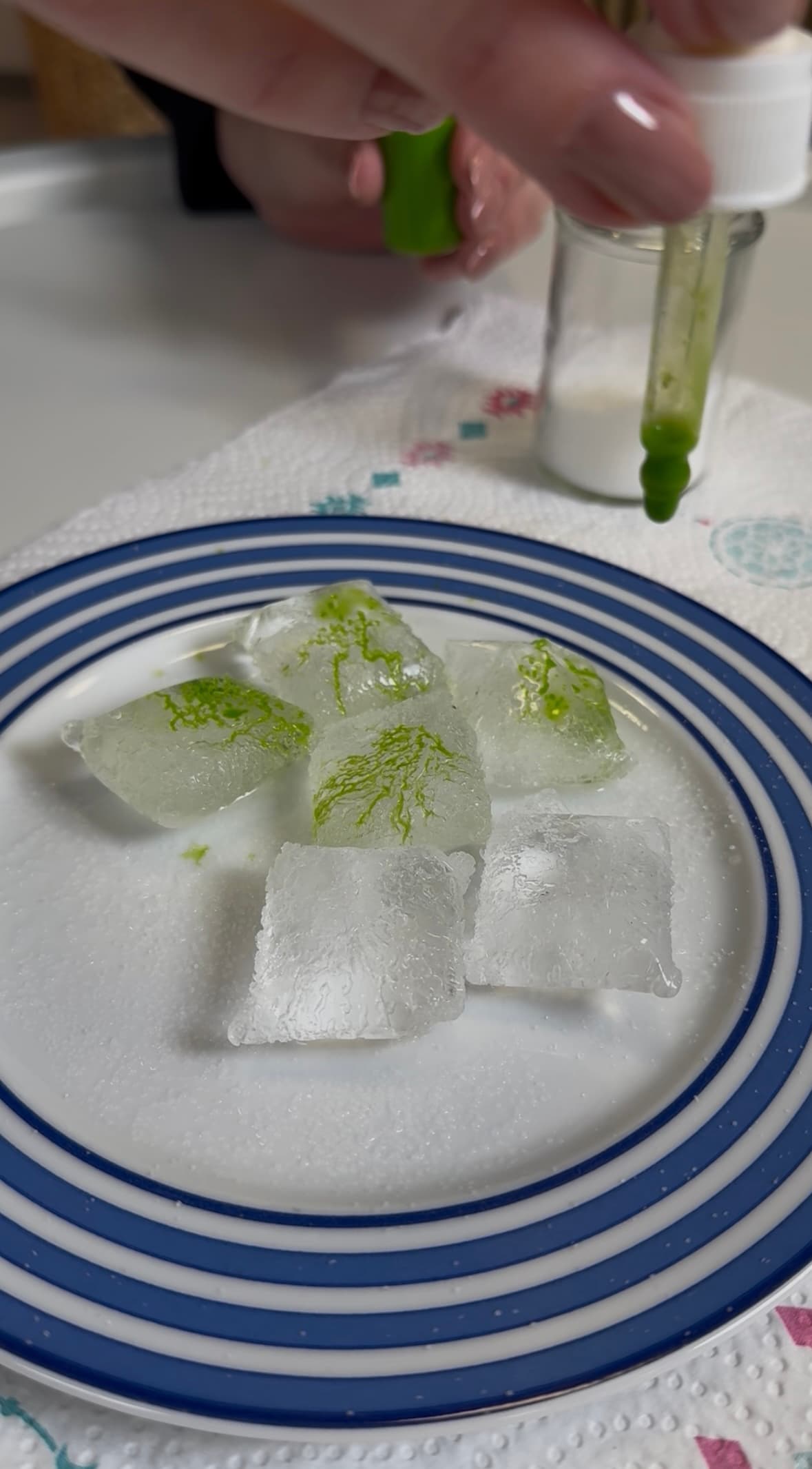 Experiment mit Eiswürfel, Farbe und Pipette.