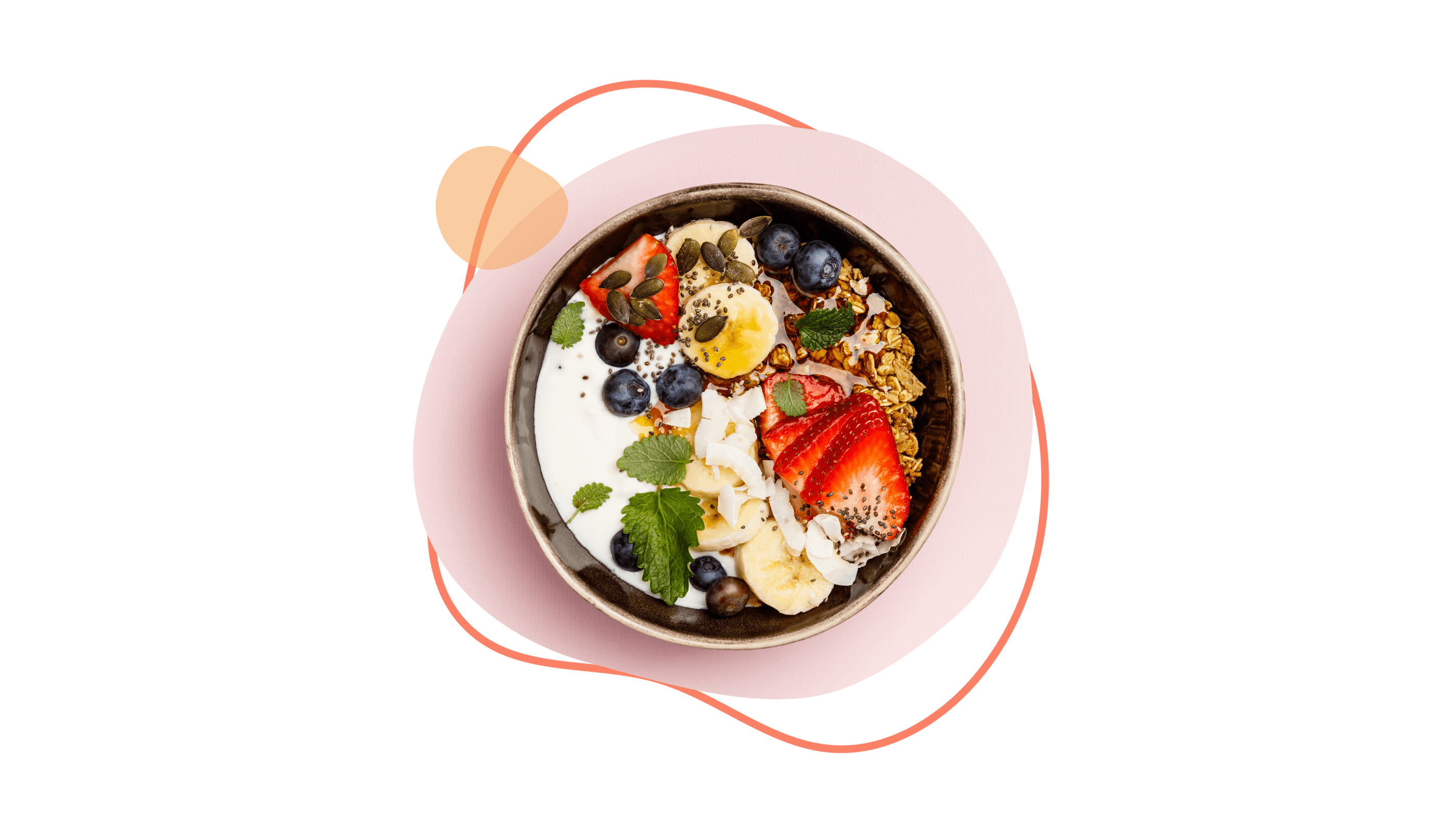 Schüssel mit Joghurt, Erdbeeren, Bananen, Heidelbeeren, Müsli und Minze auf rosa Untergrund.