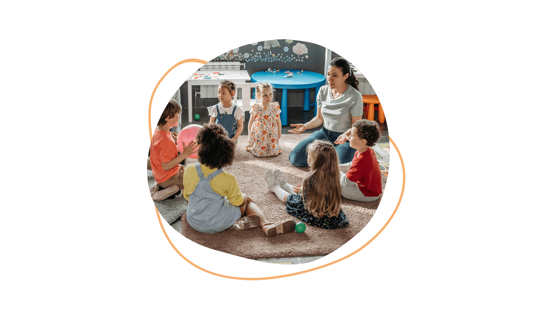 Sechs aufmerksame Kinder sitzen gemeinsam mit einer Erzieherin im Kreis.