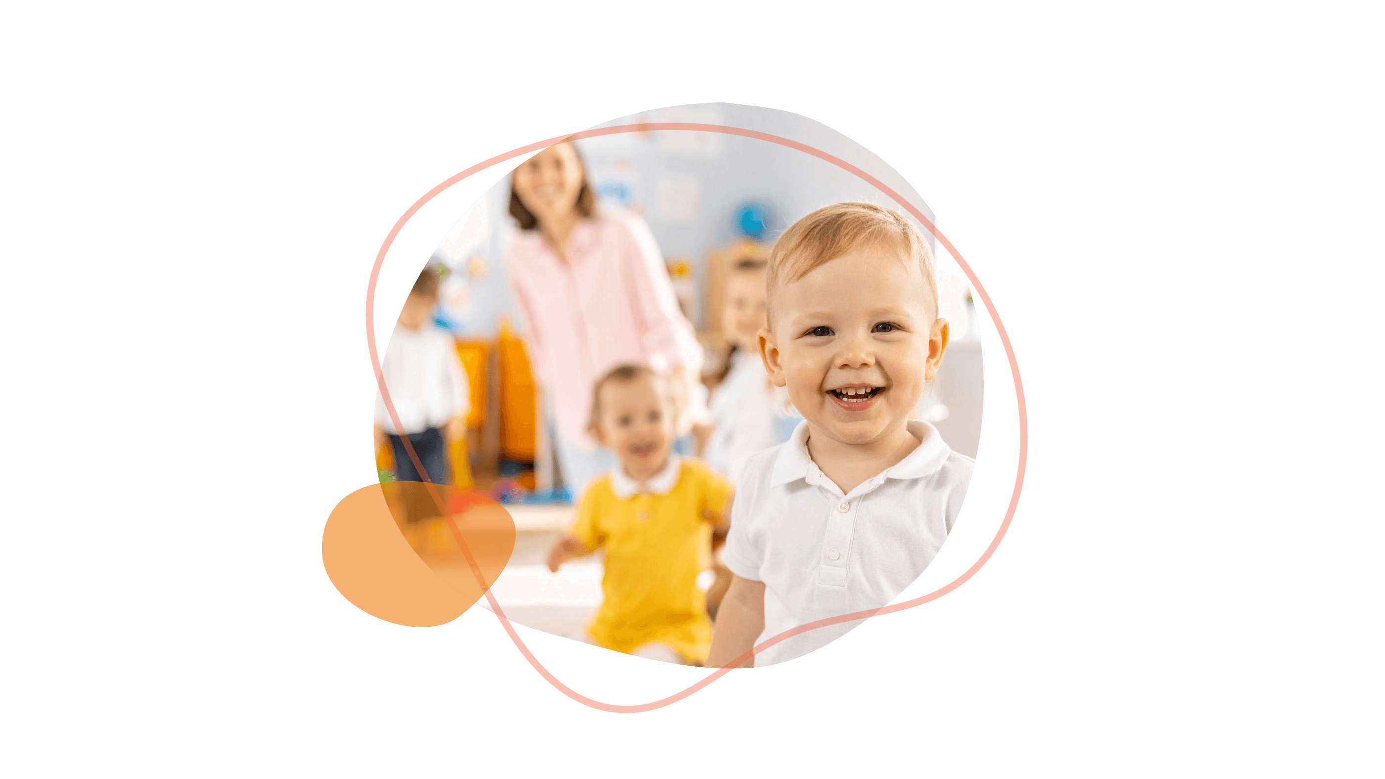 Im Vordergrund steht ein lächelndes Kleinkind in einem weißen Hemd, im Hintergrund sind andere Kinder und ein Erwachsener verschwommen zu sehen.