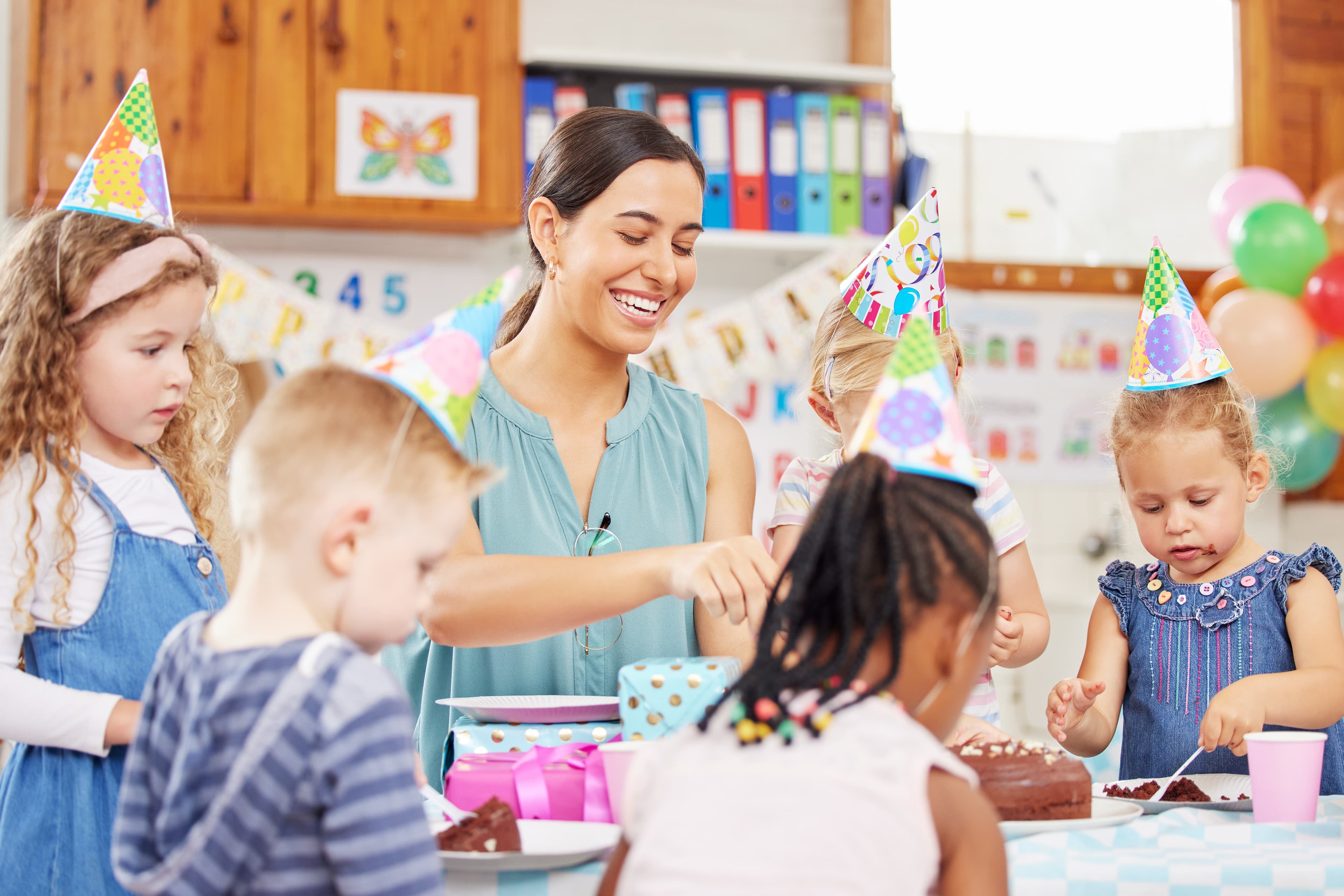 Erzieherin feiert mit Kindern Geburstag.