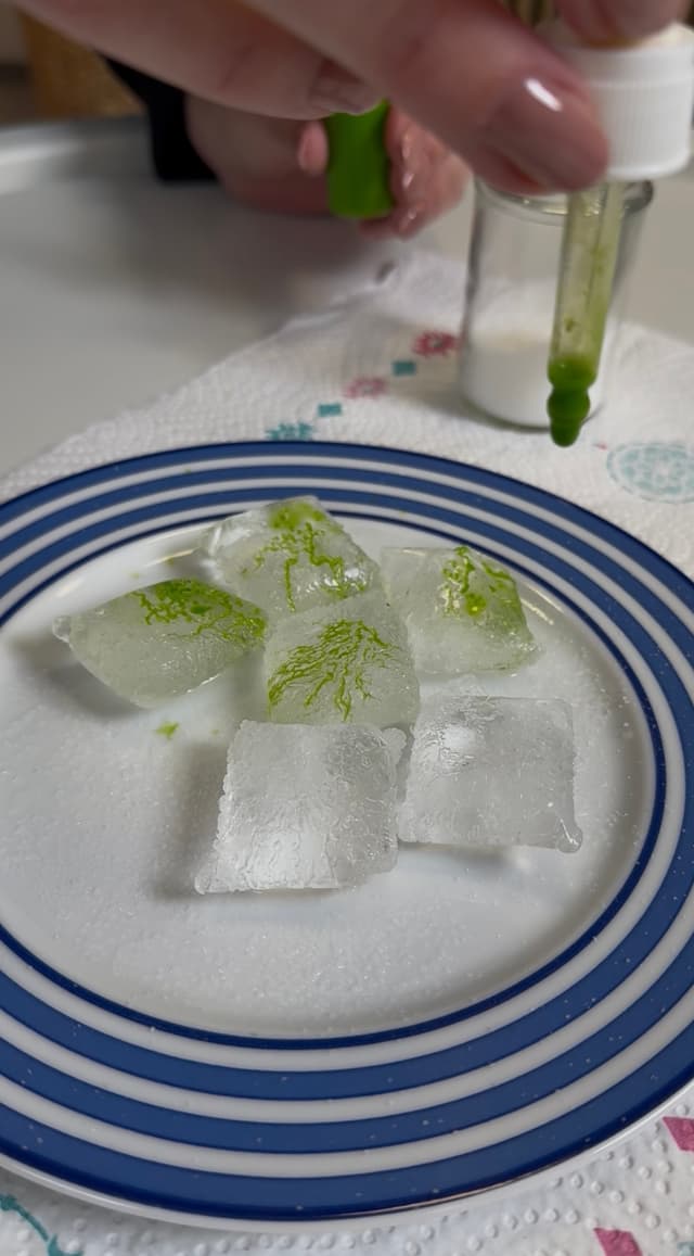 Experiment mit Eiswürfel, Farbe und Pipette.